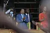 Cameroon President Paul Biya and his wife Chantal Biya applaud with a man dressed in a military uniform saluting in the background