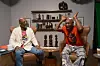 Diallo Kenyatta and Seun Kuti on the set of OkayAfrica\u2019s \u2018Bird\u2019s Eye View,\u2019 with Kenyatta wearing a beige sweater on a pink t-shirt, and Kuti and blue denim jeans