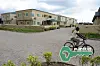 A cyclist rides past dozens of detached three-bedroom apartments.